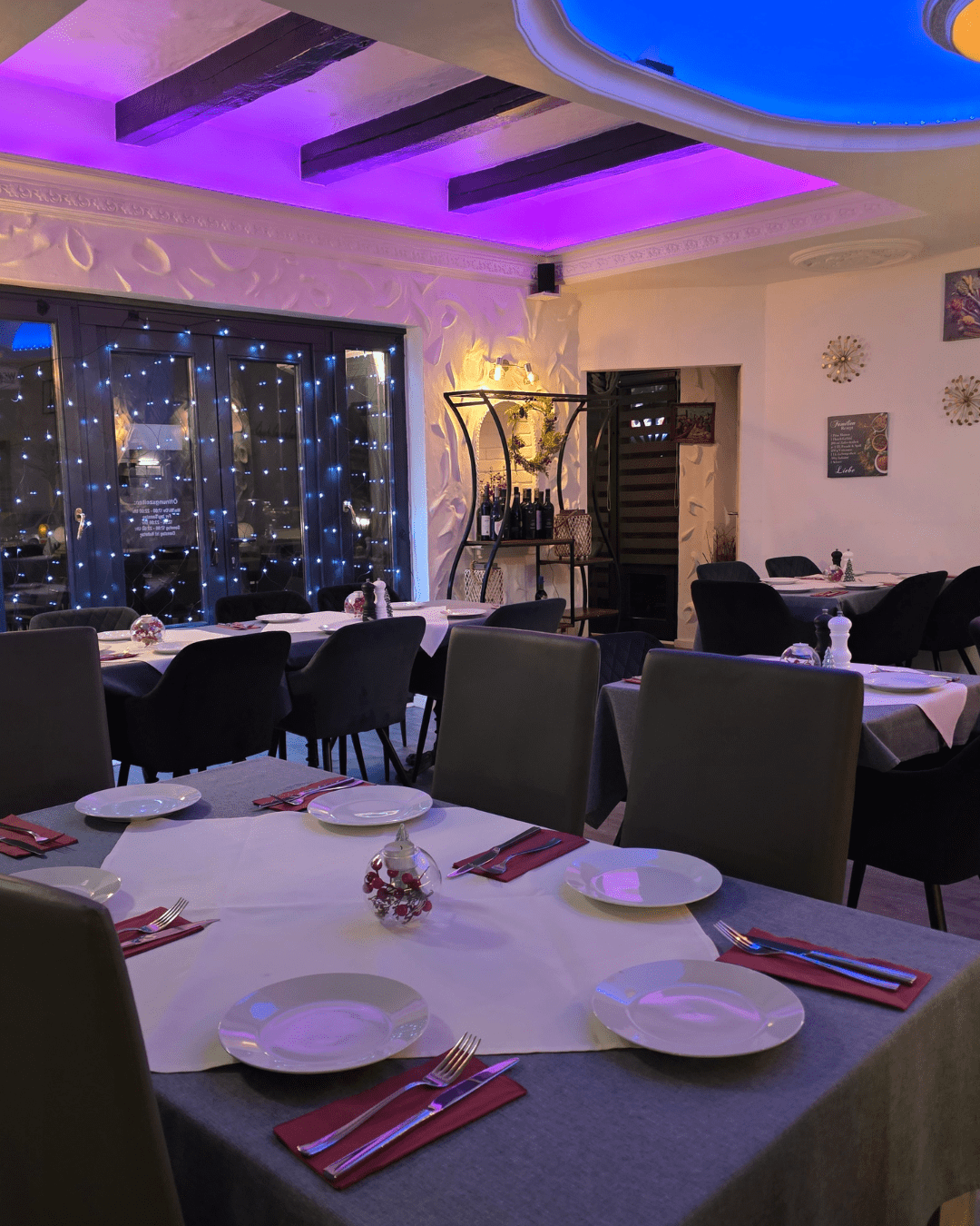 Stilvoll gedeckte Tische im modernen Restaurant Milano Huchting mit lila Beleuchtung