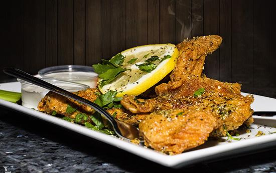 Knuspriges Hähnchenfilet mit Zitronenscheibe und Dip im Restaurant Milano Bremen Huchting