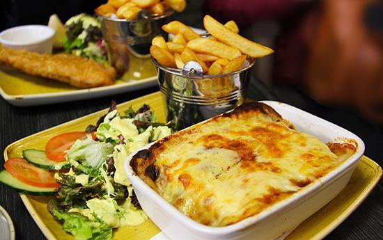 Hausgemachte Lasagne mit Käse überbacken, Pommes und frischem Salat im Restaurant Milano Bremen